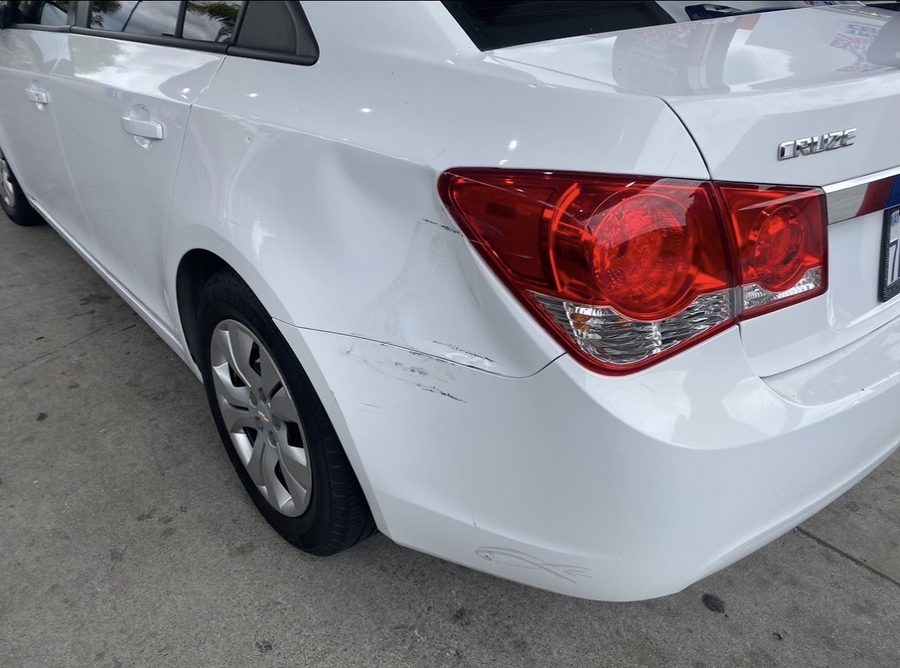 Rear bumper damage on a white Chevrolet Cruze